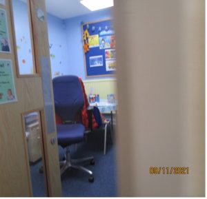 An image taken by a child showing a room in a schoool with bright images on the walls.
