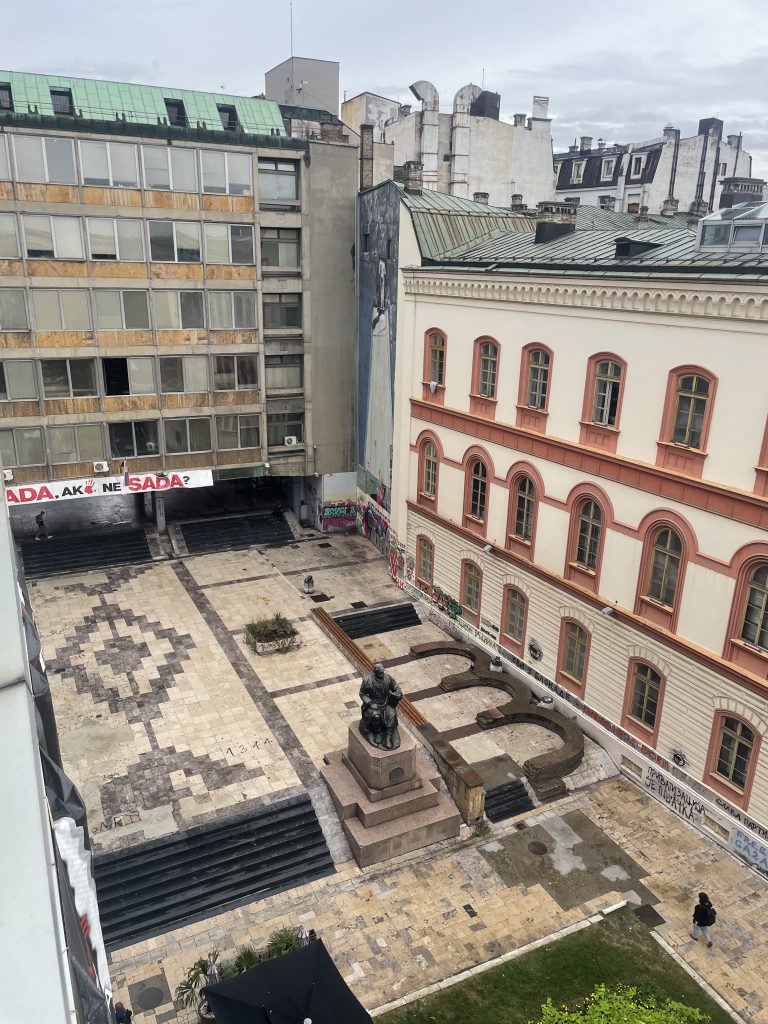 A large building with a statue in the middle of a courtyard 